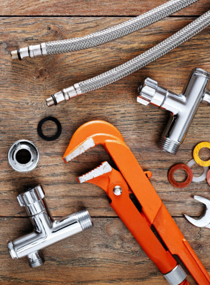 Set of plumbing tools on wooden table background. Close up top down view with copy space.
